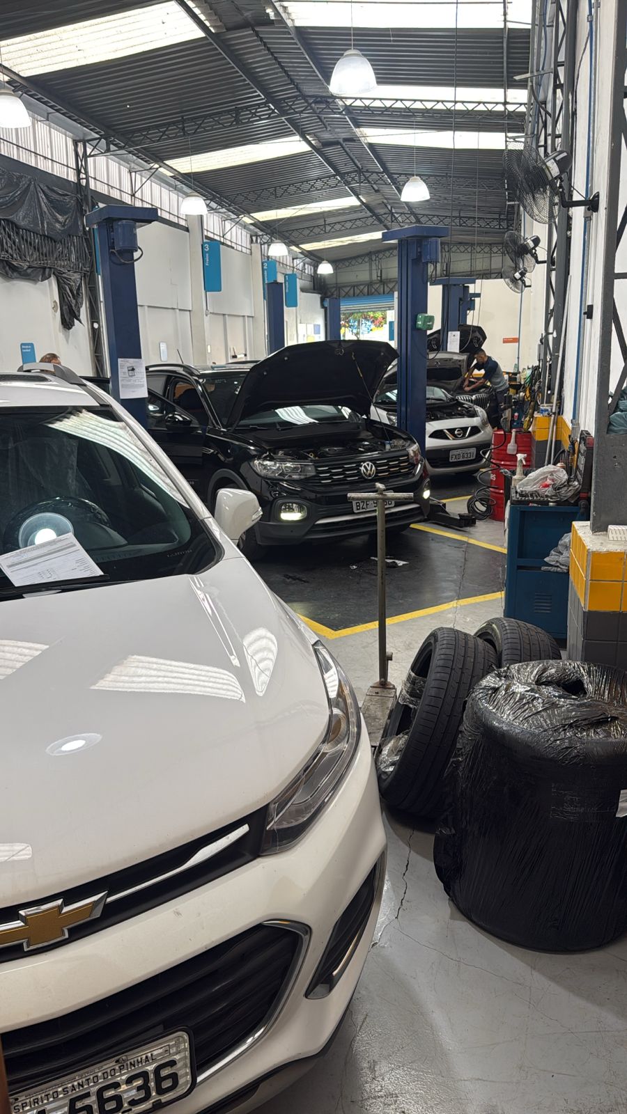 Pátio interno da oficina com carros em manutenção